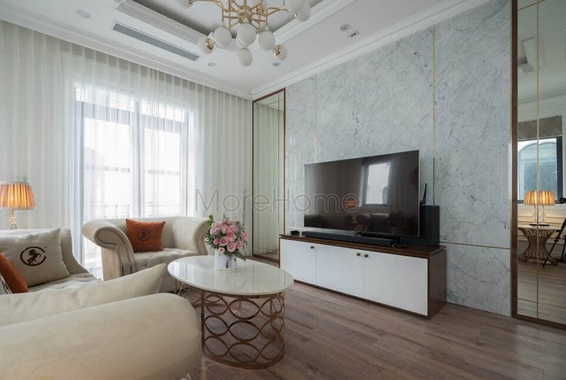 Bàn trà nhỏ hình elip như cân đối những đường nét vuông vức của bộ sofa bành tân cổ điển lớn